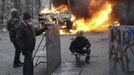 Anti-government protesters look on during clashes with riot police near Independence Square in Kiev February 20, 2014. Ukrainian protesters hurling petrol bombs and pavin