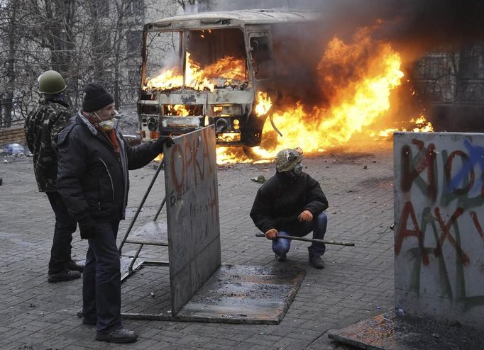 Anti-government protesters look on during clashes with riot police near Independence Square in Kiev February 20, 2014. Ukrainian protesters hurling petrol bombs and pavin