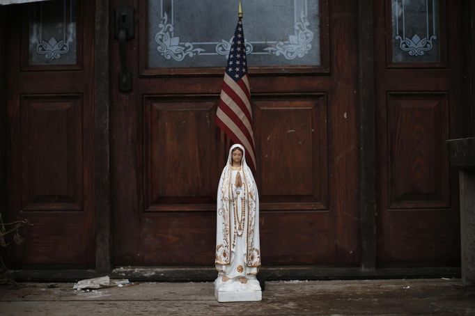 A statue of the Virgin Mary and an American Flag sit outside a home damaged and condemned by Hurricane Sandy in the New Dorp section of the south shore of Staten Island, in New York City, November 7, 2012. A potent Nor'easter, or Northeaster storm, descended on the area Wednesday where many low lying shore areas including Midland Beach were under evacuation orders as the storm packing high winds rain and snow approached the New York area just over a week after Hurricane Sandy. REUTERS/Mike Segar (UNITED STATES - Tags: ENVIRONMENT DISASTER RELIGION) Published: Lis. 7, 2012, 10:25 odp.