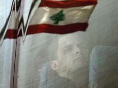 Libanonská vlajka se zrcadlí na skle autobusu, který z Bejrútu odváží občany USA.