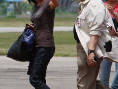 Den po svém osvobození kráčí Mary Jean Lacabová ve společnosti šéfa filipínského Červeného kříže, senátora Richarda Gordona, po ranveji základny filipínských vzdušných sil ve městě Zamboanga