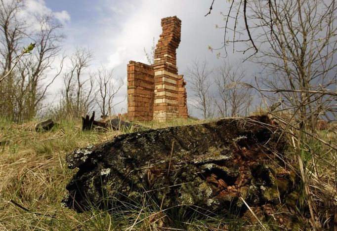 Brick chimney stands as the sole remainder of a house destroyed by fire in the abandoned village of Kazhushki