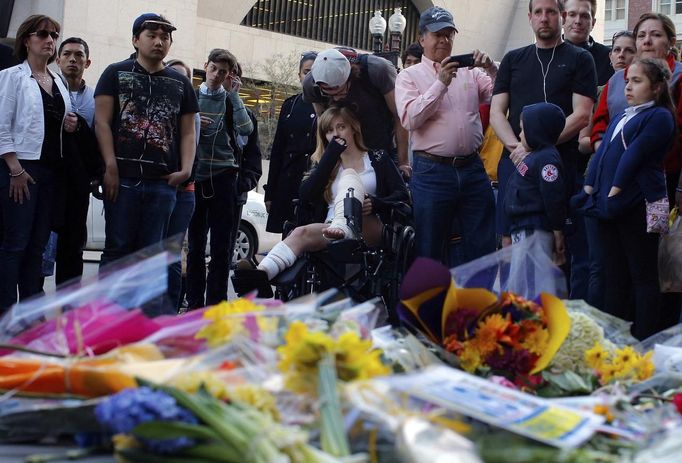 A Boston Marathon bombing survivor (C) visits the site of the first bomb explosion on Boylston Street in Boston, Massachusetts April 24, 2013. REUTERS/Brian Snyder (UNITED STATES - Tags: CRIME LAW CIVIL UNREST) Published: Dub. 24, 2013, 11:39 odp.