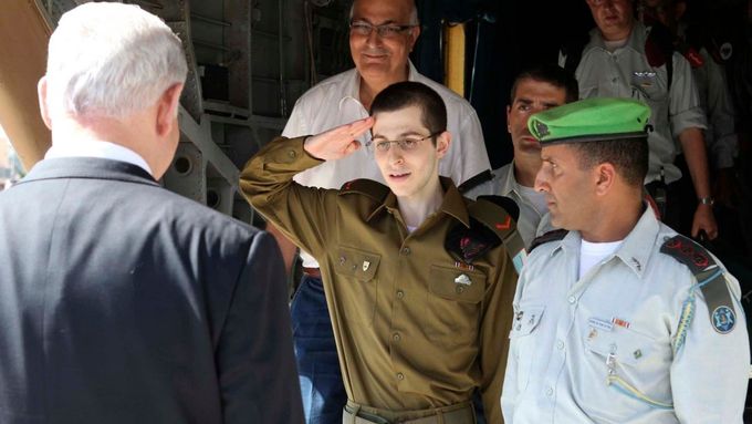 Gilad Šalit zdraví po příletu na vojenské letiště Tel Nof izraelského premiéra Netanjahua.