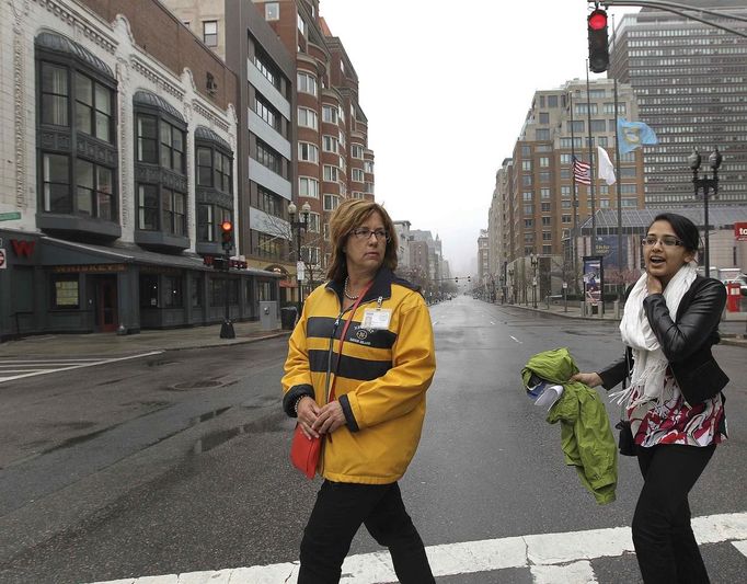 Boston city worker Christine Sullivan (L), escorts resident Stephanie Prashad back to her apartment in Boston, Massachusetts April 23, 2013. Prashad was the first person escorted back onto Boylston Street through the Hynes Convention Center as the city allowed business owners and residents to return prior to re-opening the street to the general public. The street has been closed since last week's bombings at the Boston Marathon finish line. REUTERS/Pat Greenhouse/Boston Globe/Handout (UNITED STATES) Published: Dub. 23, 2013, 7:58 odp.