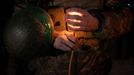 A Ukrainian soldier of the 14th separate mechanized brigade holds a candle during a Christmas Eve service near the front line outside Kupiansk as Ukrainians celebrate the