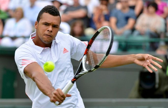 Francouzský tenista Jo-Wilfried Tsonga vrací míček Lleytonovi Hewittovi z Austrálie v 1. kole Wimbledonu 2012.