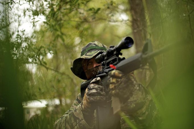 A member of the North Florida Survival Group raises his AR-15 rifle as he joins other members in performing enemy contact drills during a field training exercise in Old Town, Florida, December 8, 2012. The group trains children and adults alike to handle weapons and survive in the wild. The group passionately supports the right of U.S. citizens to bear arms and its website states that it aims to teach "patriots to survive in order to protect and defend our Constitution against all enemy threats". Picture taken December 8, 2013. REUTERS/Brian Blanco (UNITED STATES - Tags: SOCIETY POLITICS) ATTENTION EDITORS: PICTURE 10 OF 20 FOR PACKAGE 'TRAINING CHILD SURVIVALISTS' SEARCH 'FLORIDA SURVIVAL' FOR ALL IMAGES Published: Úno. 22, 2013, 1 odp.