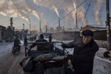 Lidé v čínském městě Šan-Si. V pozadí uhelná elektrárna (Kategorie Každodenní život. 1. místo, autor Kevin Frayer)
