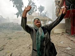 Žena v Bejrútu naříká uprostřed trosek města po bombardování izraelskými letadly.