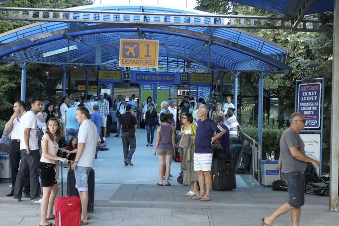 Passengers wait outside Bulgaria's Burgas airport July 18, 2012. An explosion which killed six people and injured dozens of Israeli tourists at the Bulgarian airport of Burgas was caused by a bomb in their bus, Bulgarian Foreign Minister Nikolai Mladenov told Reuters by telephone. In a statement, the foreign ministry said five people were killed and one died later in hospital. Thirty two people were taken to hospital with injuries. REUTERS/Nikolay Doncev (BULGARIA - Tags: DISASTER TRANSPORT)