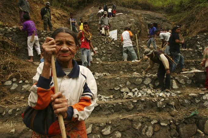 An elderly woman stands in front of stone grave called "Liang" during a ritual in the Toraja district of Indonesia's South Sulawesi Province, August 23, 2012. The ritual, called Ma'nene, involves changing the clothes every three years of mummified ancestors to honor love for the deceased. Locals believe dead family members are still with them, even if they died hundreds of years ago, a family spokesman said. Picture taken August 23, 2012. REUTERS/Yusuf Ahmad (INDONESIA - Tags: SOCIETY RELIGION) Published: Srp. 24, 2012, 1:11 odp.