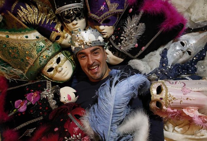 Marco Dilauro poses with his creations, which were used in previous Venice Carnivals January 25, 2013. Dilauro, 43, is a tax collector by day, but his real passion is making masks and costumes for the carnival. A resident of Como, northern Italy, he chooses fabrics, ribbons, lace and costume jewellery to make the period costumes after doing extensive research, and wears them at Carnival, which ends on the day before Ash Wednesday. Picture taken January 25, 2013. REUTERS/Alessandro Bianchi (ITALY - Tags: SOCIETY PORTRAIT) Published: Led. 27, 2013, 11:58 odp.