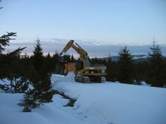 Bagr odhrabává sníh z Jizerské lyžařské magistrály.