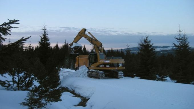 Bagr odhrabává sníh z Jizerské lyžařské magistrály.