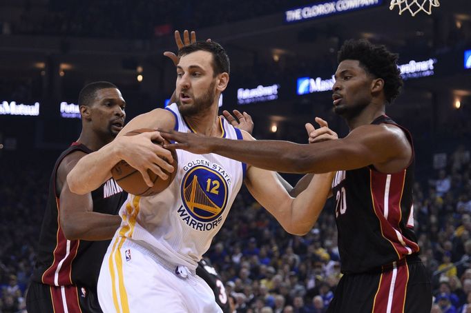 Andrew Bogut z Golden State (12) bráněný dvojicí hráčů Miami Chris Bosh (vlevo) a Justise Winslow.