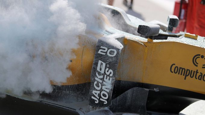 Magnussenův Renault po rychlém zásahu hasičů v boxech v Sepangu.
