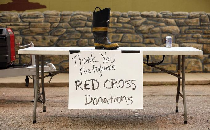 A firefighter's boot sits on a table for donations to the Red Cross outside the Double S Bar in Laporte, Colorado June 10, 2012. The town is on the eastern edge of the High Park Fire. The fire started on Saturday and was estimated at more than 14,000 acres on Sunday morning. At least 18 structures were lost or damaged due to the fire with more threatened and officials are searching for one person believed to be missing. The cause of the fire is unknown and it remains at zero percent containment. REUTERS/Marc Piscotty (UNITED STATES - Tags: DISASTER ENVIRONMENT SOCIETY) Published: Čer. 10, 2012, 11:59 odp.