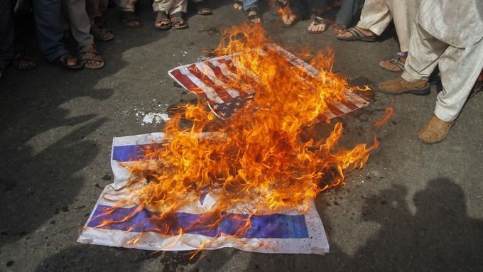 Supporters from the Jamaat Ahle Sunnat Pakistan religious political party burn U.S and Israel flags during an anti-American protest in Karachi September 19, 2012. Some 700 protesters gathered in a demonstration to condemn a film produced in the U.S. mocking the Prophet Mohammad. REUTERS/Athar Hussain (PAKISTAN - Tags: POLITICS CIVIL UNREST RELIGION) Published: Zář. 19, 2012, 3:39 odp.