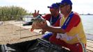 Valeriu Martoiu (L) and Ionel Ghelase (R) of Romania pose with a carp they caught during the 14th Carpfishing World Championship in Corbu village, 310 km (192 miles) east of Bucharest, September 29, 2012. REUTERS/Radu Sigheti (ROMANIA - Tags: SOCIETY) Published: Zář. 29, 2012, 4:30 odp.