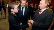 Ze zákulisí zahajovacího ceremoniálu: Louis Sarkozy (vlevo) se zdraví s ruským premiérem Vladimírem Putinem, přihlíží otec Nicolas Sarkozy, prezident Francie.