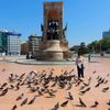 Žena krmí holuby na Taksimském náměstí v Istanbulu