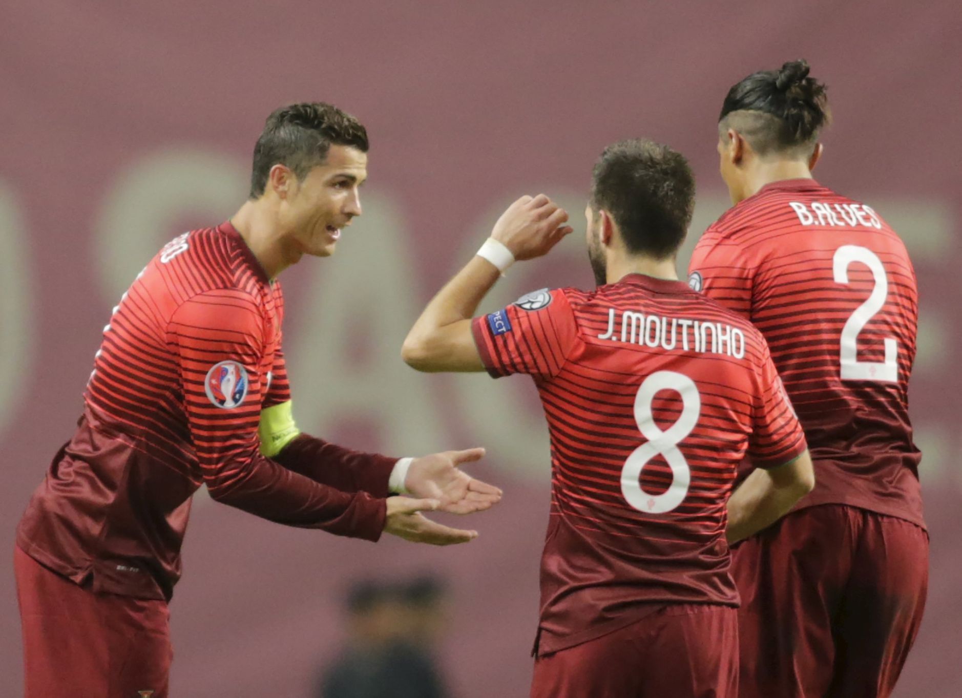 Portugal's Moutinho celebrates his goal against Denmark with his teammate Alves and Ronaldo during their Euro 2016 qualifying soccer match at Municipal Stadium in Braga