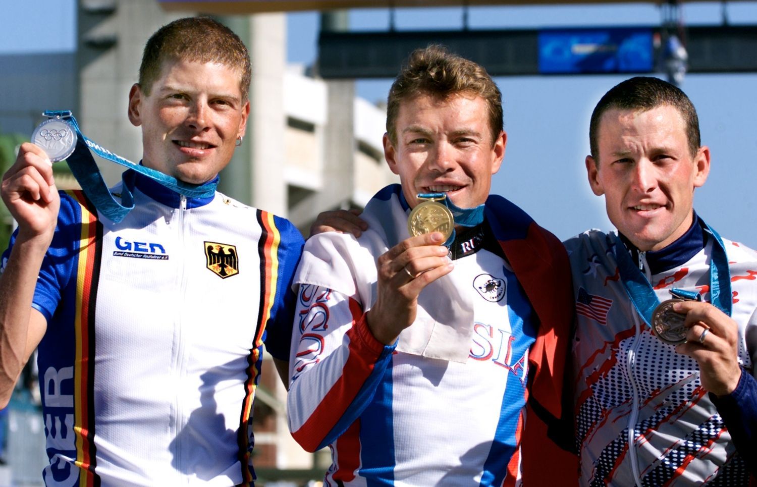 Americký cyklista Lance Armstrong (vpravo) pózuje společně s Rusem Vjačeslavem Jekimovem (uprostřed) a Němcem Janem Ullrichem s medailemi na OH 2000 v Sydney.