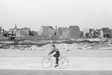 Chlapec jede na kole kolem ruin budov ve Východním Berlíně (1959).