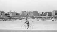 Chlapec jede na kole kolem ruin budov ve Východním Berlíně (1959).