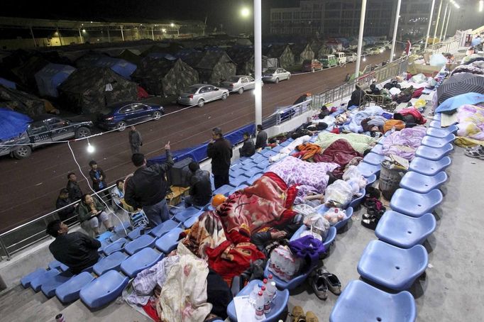 Residents sleep on the seats of a stadium, after Saturday's earthquake, in Baoxing county, Sichuan province, early April 22, 2013. Rescuers struggled to reach a remote, rural corner of southwestern China on Sunday as the toll of the dead and missing from the country's worst earthquake in three years climbed to 208 with almost 1,000 serious injuries. The 6.6 magnitude quake struck in Lushan county, near the city of Ya'an in the southwestern province of Sichuan, close to where a devastating 7.9 quake hit in May 2008, killing 70,000. REUTERS/Stringer (CHINA - Tags: DISASTER SOCIETY) CHINA OUT. NO COMMERCIAL OR EDITORIAL SALES IN CHINA Published: Dub. 22, 2013, 2:59 dop.