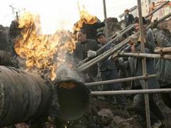 Dělníci spravují plynovod na jihozápadě Číny.