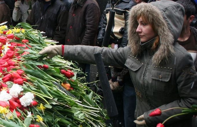 Mladá žena pokládá květinu k věčnému ohni, který symbolizuje, že vzpomínka na genocidu nikdy nezapadne.