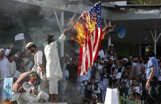 Afghan protesters set fire to a U.S. flag as they shout slogans during a demonstration in Kabul, September 21, 2012. Hundreds of Afghans protested against a U.S.-made film they say insults the Prophet Mohammad. REUTERS/Omar Sobhani (AFGHANISTAN - Tags: RELIGION) Published: Zář. 21, 2012, 12:12 odp.