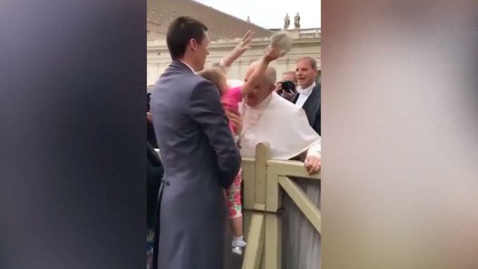 Malá holčička sebrala papeži pokrývku hlavy.