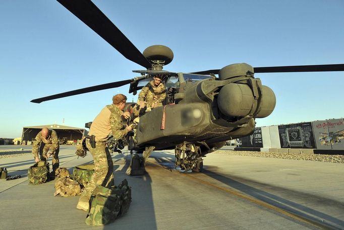 Britain's Prince Harry (C) carries out a pre-flight check to his Apache helicopter in Camp Bastion, southern Afghanistan in this photograph taken November 1, 2012, and released January 21, 2013. The Prince, who is serving as a pilot/gunner with 662 Squadron Army Air Corps, is on a posting to Afghanistan that runs from September 2012 to January 2013. Photograph taken November 1, 2012. Photograph pixelated at source. REUTERS/John Stillwell/Pool (AFGHANISTAN - Tags: MILITARY POLITICS SOCIETY ROYALS CONFLICT) Published: Led. 21, 2013, 8:01 odp.