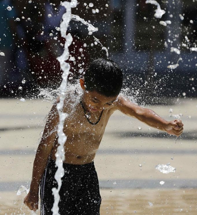 Tyler Quintanilla, 5 years old, from Washington, plays in a water fountain to beat the heat gripping the nation's capital while in the Capital Heights neighborhood of Washington, July 2, 2012. REUTERS/Larry Downing (UNITED STATES - Tags: SOCIETY ENVIRONMENT) Published: Čec. 2, 2012, 8:11 odp.