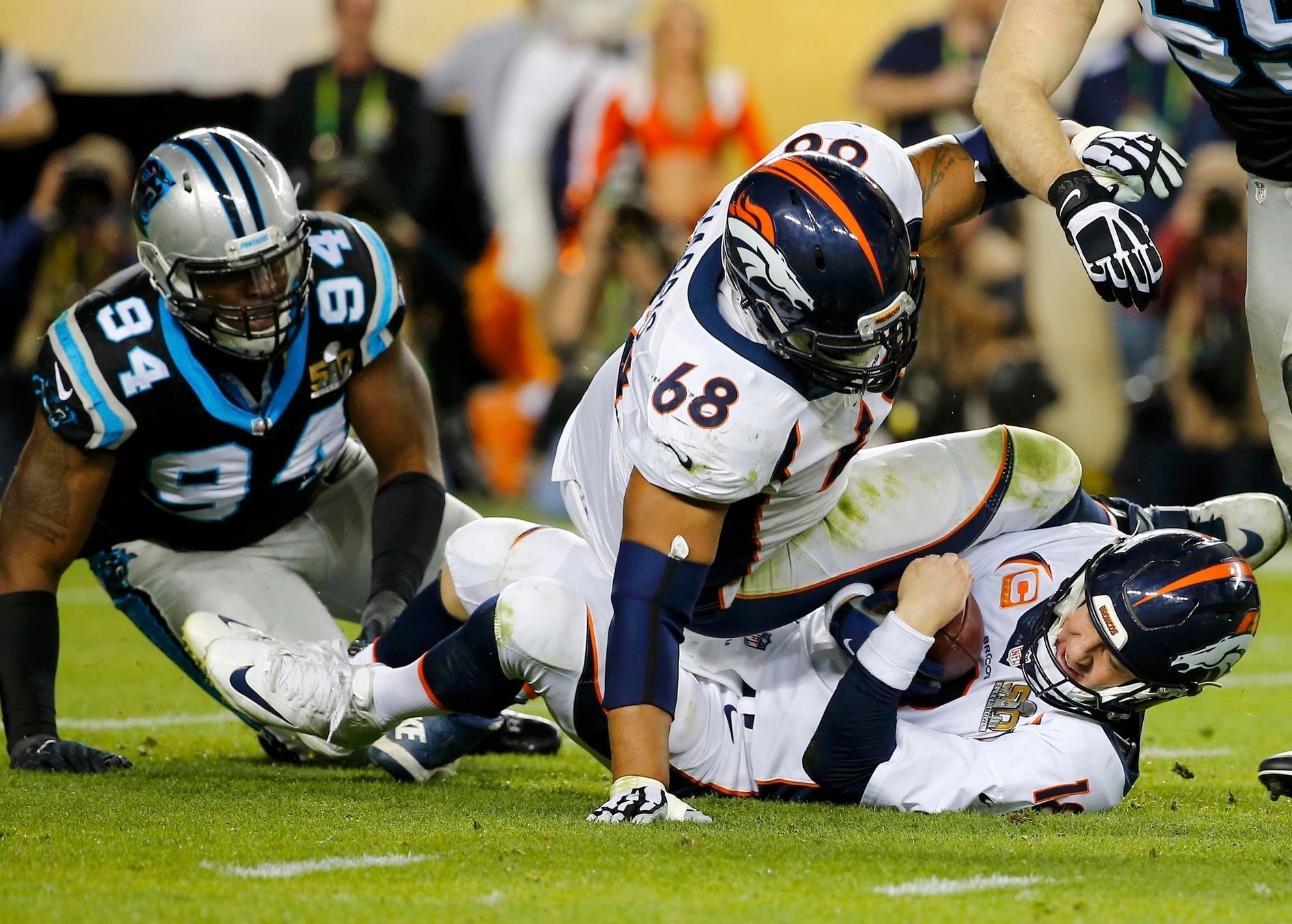 Denver Broncos' quarterback Manning is sacked by Carolina Panthers' Ealy as Broncos' Harris falls on Manning in the third quarter during the NFL's Super Bowl 50 football game in Santa Clara