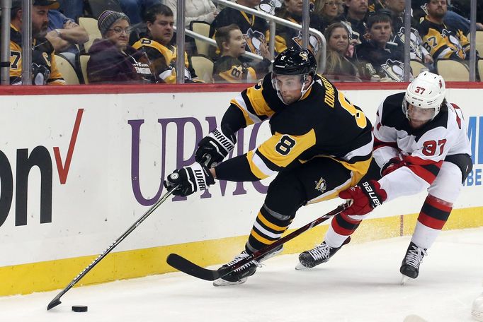 Jan 28, 2019; Pittsburgh, PA, USA;  Pittsburgh Penguins defenseman Brian Dumoulin (8) moves the puck against pressure from New Jersey Devils center Pavel Zacha (37) durin