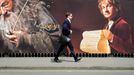 A man walks along a fence hung with large format hoardings of J. R. R. Tolkien characters from The Hobbit movie in Wellington November 27, 2012. New Zealand's capital city was rushing to complete its transformation into a haven for hairy feet and pointed ears on Tuesday as stars jetted in for the long-awaited world premiere of the first movie of the Hobbit trilogy. REUTERS/Mark Coote (NEW ZEALAND - Tags: ENTERTAINMENT) Published: Lis. 27, 2012, 3:04 dop.