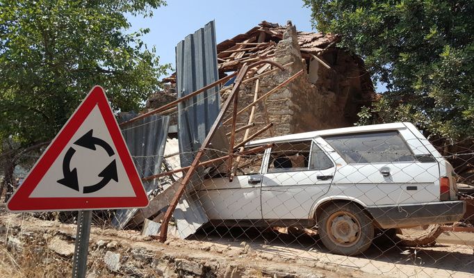 Zničené auto a dům ve vesnici nedaleko tureckého města Bodrum.