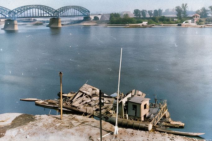 Fotografie zachycuje zničenou loď na řece Visle v obléhané Varšavě v září 1939. Kolorovaný snímek.