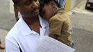 Jean Toussaint of West Palm Beach holds his son Isaac, 2, as they wait for hours in a long line of voters at the Supervisor of Elections office in West Palm Beach, Florida November 5, 2012. Palm Beach County Supervisor of Elections Supervisor Susan Bucher is one of five supervisors in heavily populated counties who has allowed in-person absentee voting after Florida Republican Governor Rick Scott refused to extend early voting. REUTERS/Joe Skipper (UNITED STATES - Tags: POLITICS ELECTIONS USA PRESIDENTIAL ELECTION) Published: Lis. 5, 2012, 5:34 odp.