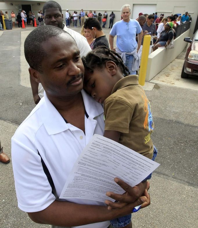 Jean Toussaint of West Palm Beach holds his son Isaac, 2, as they wait for hours in a long line of voters at the Supervisor of Elections office in West Palm Beach, Florida November 5, 2012. Palm Beach County Supervisor of Elections Supervisor Susan Bucher is one of five supervisors in heavily populated counties who has allowed in-person absentee voting after Florida Republican Governor Rick Scott refused to extend early voting. REUTERS/Joe Skipper (UNITED STATES - Tags: POLITICS ELECTIONS USA PRESIDENTIAL ELECTION) Published: Lis. 5, 2012, 5:34 odp.