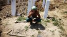 A worker smokes during a break after digging graves ahead of a ceremony at a memorial centre for Srebrenica Massacre victims in Potocari July 7, 2012. Tens of thousands of family members, foreign dignitaries and guests are expected to attend a ceremony in Srebrenica on July 11 marking the 17th anniversary of the massacre in which Bosnian Serb forces commanded by Ratko Mladic killed up to 8,000 Muslim men and boys. Nearly 510 identified victims will be buried at a memorial cemetery during the ceremony, their bodies found in some 60 mass graves around the town. REUTERS/Dado Ruvic (BOSNIA AND HERZEGOVINA - Tags: CONFLICT ANNIVERSARY POLITICS TPX IMAGES OF THE DAY) Published: Čec. 7, 2012, 3:23 odp.