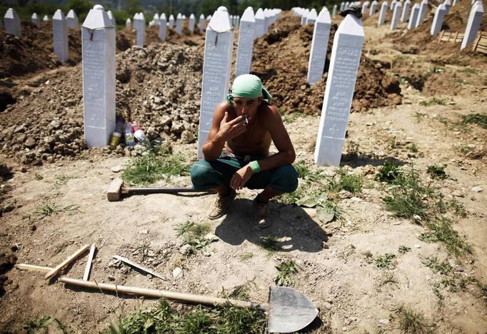 A worker smokes during a break after digging graves ahead of a ceremony at a memorial centre for Srebrenica Massacre victims in Potocari July 7, 2012. Tens of thousands of family members, foreign dignitaries and guests are expected to attend a ceremony in Srebrenica on July 11 marking the 17th anniversary of the massacre in which Bosnian Serb forces commanded by Ratko Mladic killed up to 8,000 Muslim men and boys. Nearly 510 identified victims will be buried at a memorial cemetery during the ceremony, their bodies found in some 60 mass graves around the town. REUTERS/Dado Ruvic (BOSNIA AND HERZEGOVINA - Tags: CONFLICT ANNIVERSARY POLITICS TPX IMAGES OF THE DAY) Published: Čec. 7, 2012, 3:23 odp.