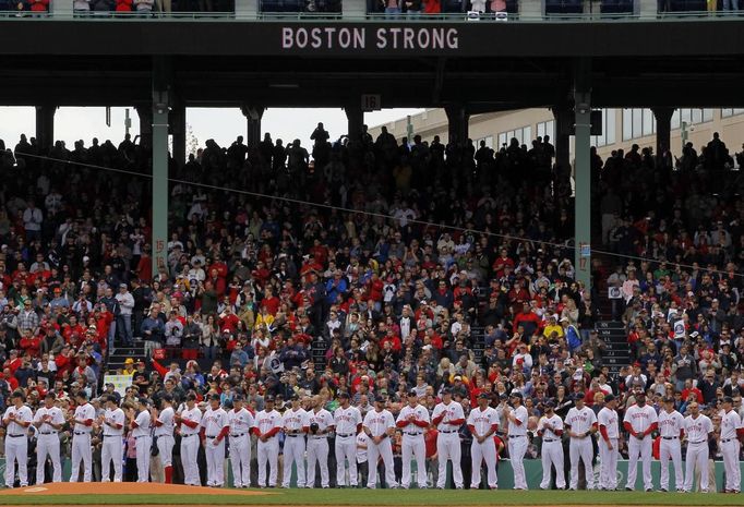 Boston Red Sox players stand on the field during a pre-game ceremony honoring the victims of the Boston Marathon bombings, before the team's MLB American League baseball game against the Kansas City Royals at Fenway Park in Boston, Massachusetts April 20, 2013. REUTERS/Jessica Rinaldi (UNITED STATES - Tags: SPORT BASEBALL TPX IMAGES OF THE DAY) Published: Dub. 20, 2013, 9:33 odp.