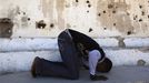 Somali athlete Abdullah Bare Kuulow prays after a training session as part of their preparations for the 2012 London Olympic Games inside the stadium in Somalia's capital Mogadishu March 16, 2012 file photo. Training in a bullet-riddled stadium where the remains of a rocket propelled grenade lies discarded on the track's edge counts as progress for Somali Olympic hopeful Mohamed Hassan Mohamed. A year ago, Mogadishu's Konis stadium was a base for Islamist militants and a work out meant at times running through the streets, dodging gun-fire and mortar shells in one of the world's most dangerous cities. To match OLY-SOMALIA-HOPES/ REUTERS/Feisal Omar/Files (SOMALIA - Tags: SPORT OLYMPICS ATHLETICS) Published: Čer. 11, 2012, 6:50 dop.