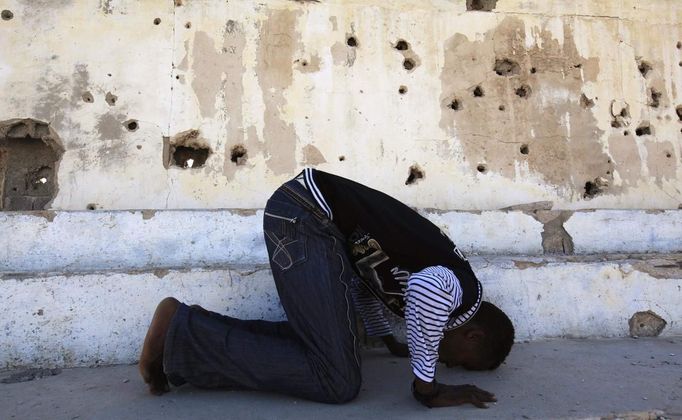 Somali athlete Abdullah Bare Kuulow prays after a training session as part of their preparations for the 2012 London Olympic Games inside the stadium in Somalia's capital Mogadishu March 16, 2012 file photo. Training in a bullet-riddled stadium where the remains of a rocket propelled grenade lies discarded on the track's edge counts as progress for Somali Olympic hopeful Mohamed Hassan Mohamed. A year ago, Mogadishu's Konis stadium was a base for Islamist militants and a work out meant at times running through the streets, dodging gun-fire and mortar shells in one of the world's most dangerous cities. To match OLY-SOMALIA-HOPES/ REUTERS/Feisal Omar/Files (SOMALIA - Tags: SPORT OLYMPICS ATHLETICS) Published: Čer. 11, 2012, 6:50 dop.