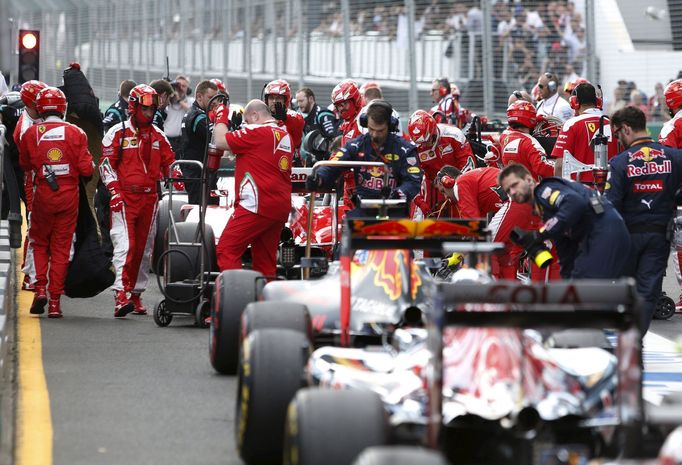 F1 cars sit in in pit lane after a crash between McLaren F1 driver Fernando Alonso and Haas F1 driver Esteban Gutierrez, which temporarily stopped the race, during the Au